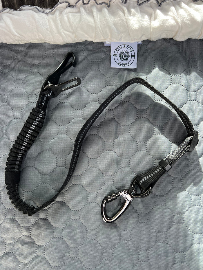 The Anchor dog car seat belt laid out on the grey seat cover
